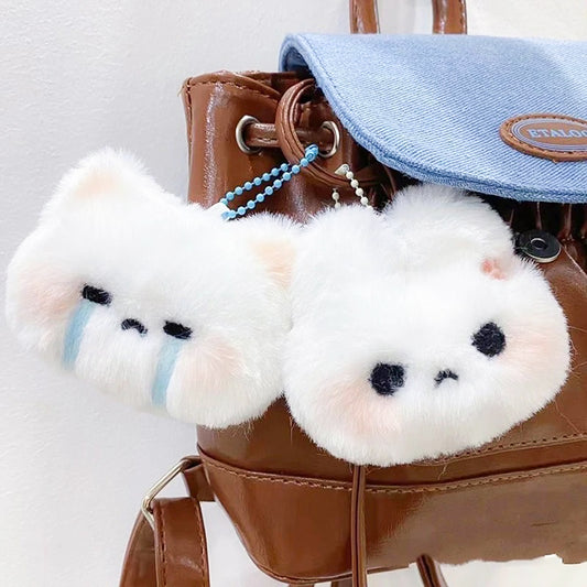 Crying and grumpy cat plush keychains hanging from a brown leather bag, adding kawaii charm