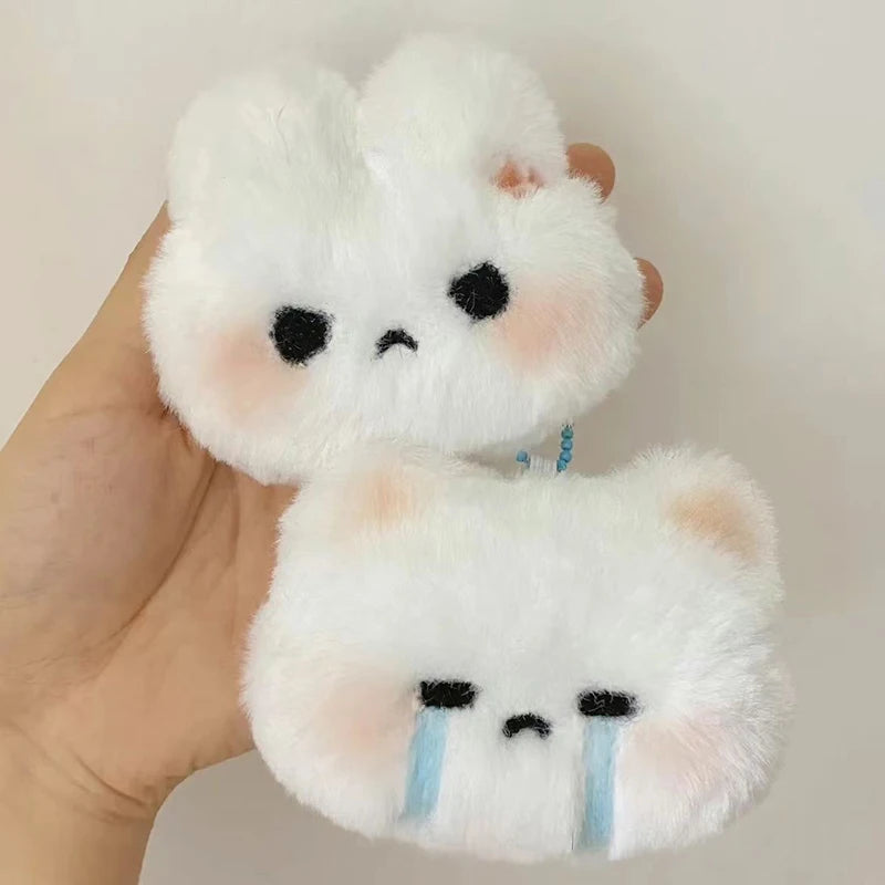 Set of two fluffy cat keychains, one with a crying face and the other with a grumpy expression