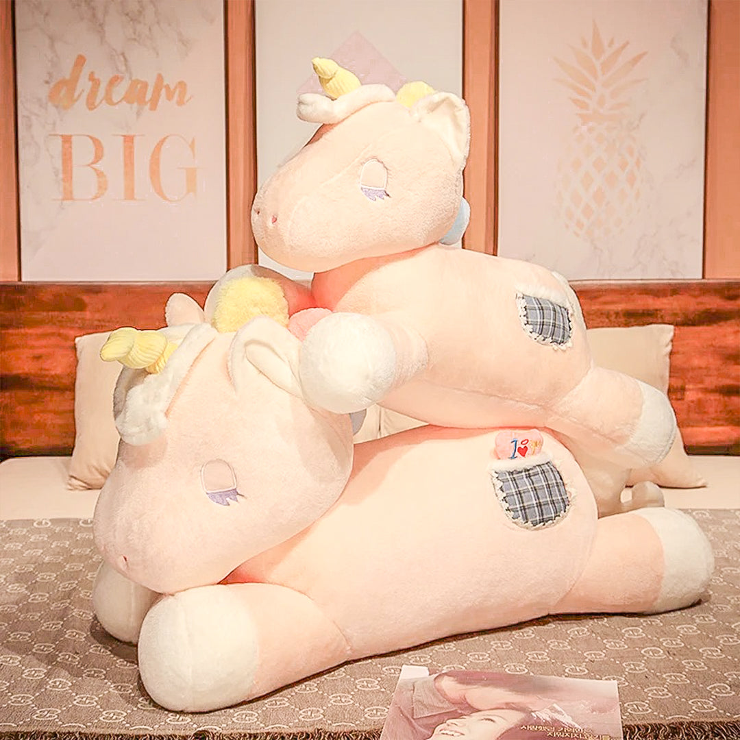 A whimsical gigantic unicorn plush toy in a bright, colorful setting, designed to inspire imaginative adventures